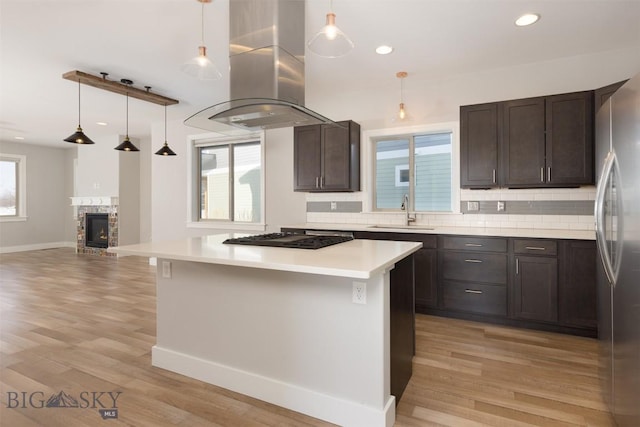 500 Westgate, Bozeman, MT 59718 - kitchen with black gas stovetop, island range hood, a sink, freestanding refrigerator, and backsplash