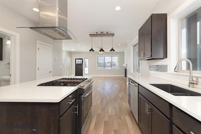 500 Westgate, Bozeman, MT 59718 - kitchen featuring stainless steel appliances, a sink, island exhaust hood, dark brown cabinets, and light wood finished floors