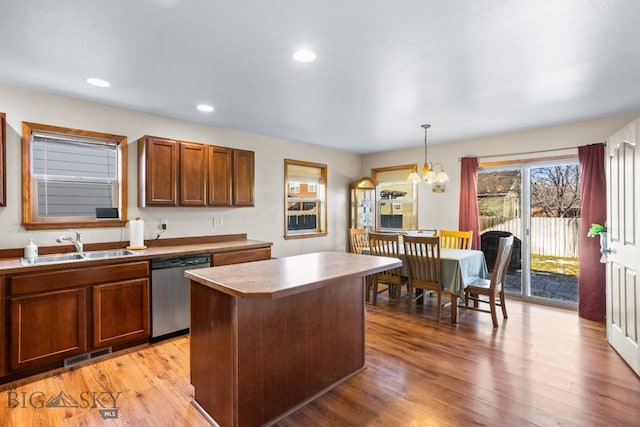1014 Idaho St, Belgrade, MT 59714 - kitchen with dishwasher, a chandelier, a kitchen island, light wood-style floors, and pendant lighting