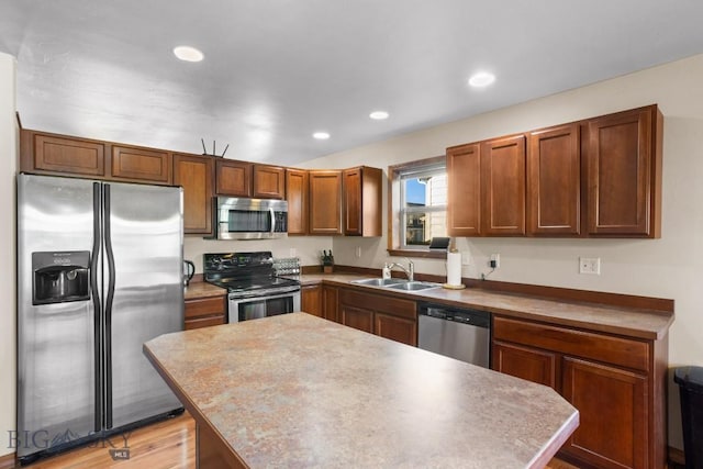 1014 Idaho St, Belgrade, MT 59714 - kitchen featuring appliances with stainless steel finishes, a kitchen island, recessed lighting, brown cabinets, and light wood-style flooring