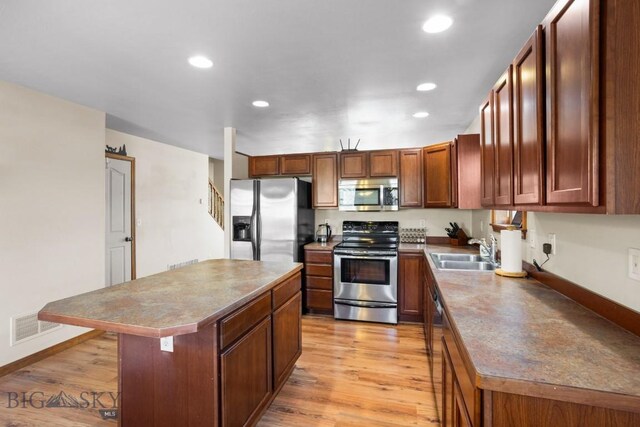 1014 Idaho St, Belgrade, MT 59714 - kitchen with stainless steel appliances, a center island, recessed lighting, light wood-style flooring, and a breakfast bar