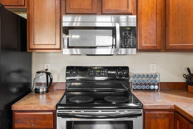 1014 Idaho St, Belgrade, MT 59714 - kitchen with appliances with stainless steel finishes and brown cabinetry