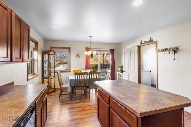 1014 Idaho St, Belgrade, MT 59714 - kitchen with light wood-style floors, a chandelier, dark countertops, a center island, and decorative light fixtures