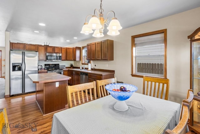 1014 Idaho St, Belgrade, MT 59714 - kitchen with stainless steel appliances, a chandelier, wood finished floors, hanging light fixtures, and a center island