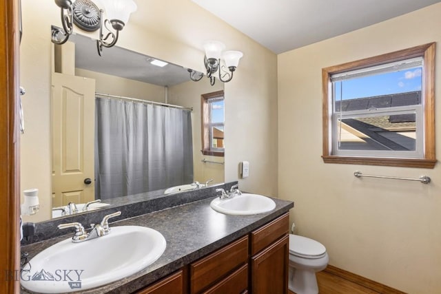 1014 Idaho St, Belgrade, MT 59714 - bathroom featuring double vanity, curtained shower, wood finished floors, and a chandelier