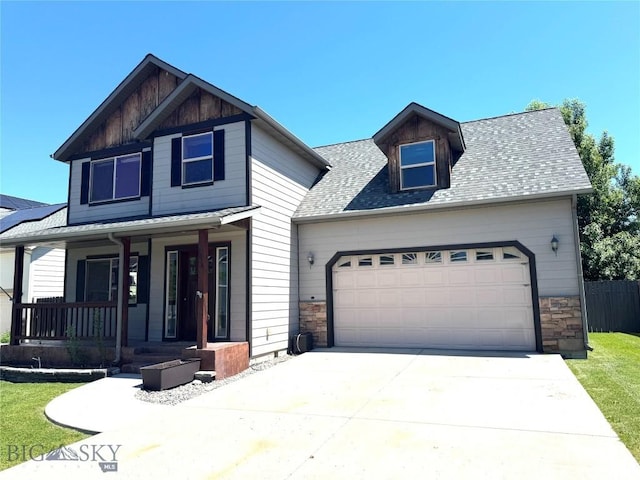 1014 Idaho St, Belgrade, MT 59714 - view of front of property featuring a porch, stone siding, a garage, driveway, and roof with shingles