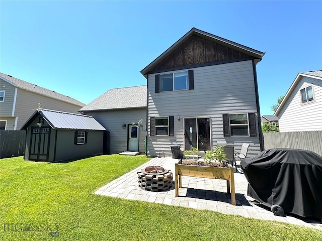 1014 Idaho St, Belgrade, MT 59714 - rear view of property with an outdoor fire pit, a patio, a storage unit, and board and batten siding