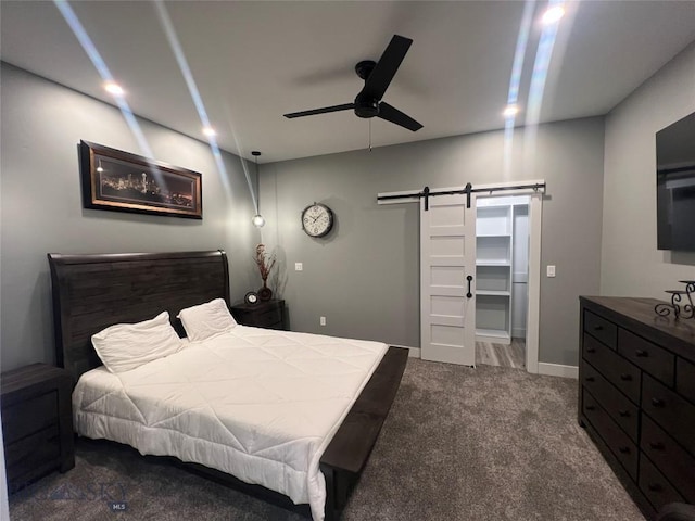 bedroom with ceiling fan, a barn door, recessed lighting, baseboards, and dark colored carpet