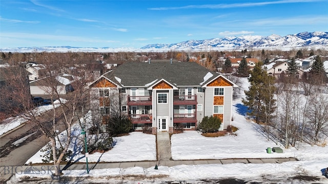 view of front of property with a mountain view and a balcony