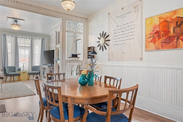dining space featuring a wainscoted wall and wood finished floors