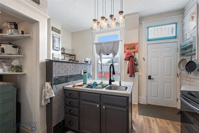 kitchen with range with electric cooktop, wood finished floors, decorative light fixtures, gray cabinets, and a sink