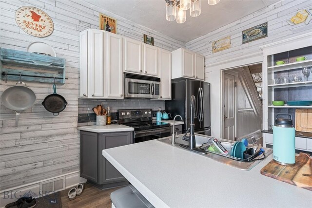 kitchen with visible vents, dark wood finished floors, stainless steel appliances, light countertops, and a sink