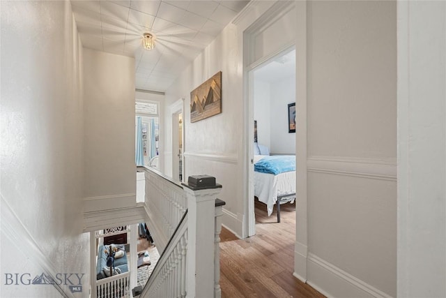 corridor with baseboards and wood finished floors