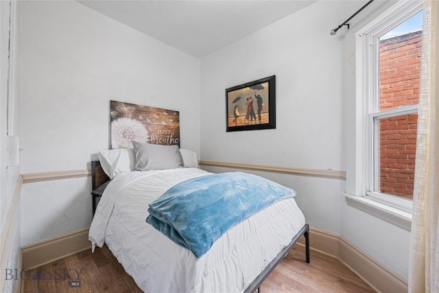 bedroom featuring baseboards and wood finished floors