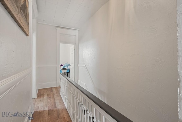 hall with a textured wall and light wood finished floors