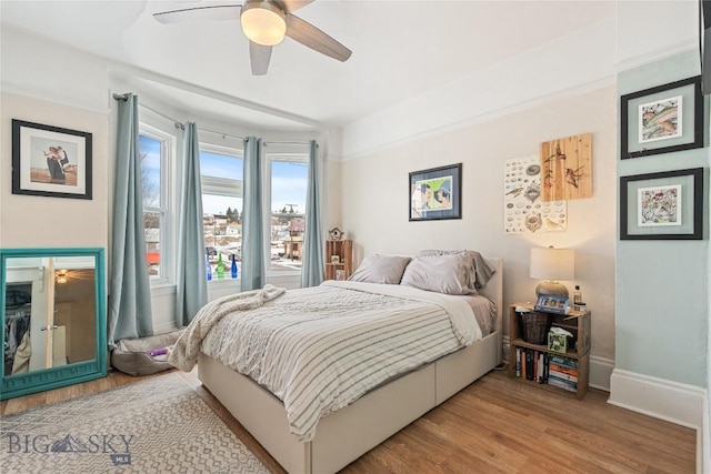 bedroom featuring ceiling fan, wood finished floors, and baseboards
