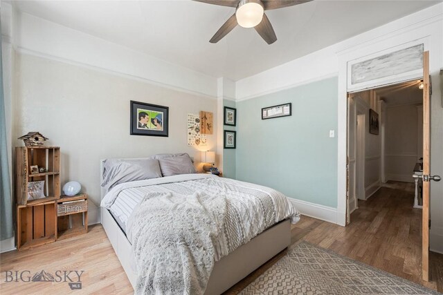 bedroom featuring baseboards, light wood-style flooring, and a ceiling fan