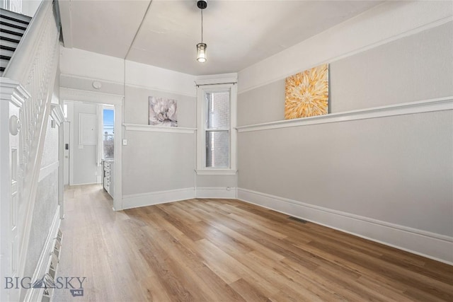 interior space with visible vents, baseboards, and wood finished floors