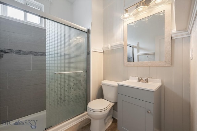 full bath with a tile shower, vanity, and toilet