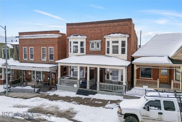 view of front facade featuring covered porch and brick siding