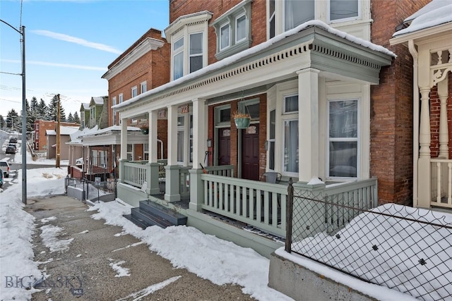 view of front of house featuring covered porch and brick siding