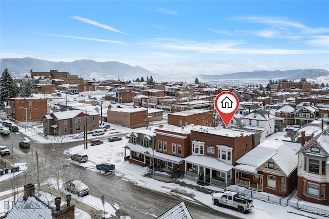 snowy aerial view featuring a residential view and a mountain view