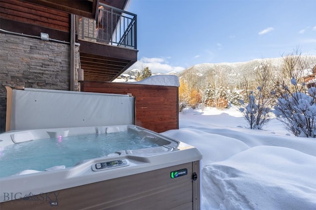 exterior space featuring a mountain view and a hot tub