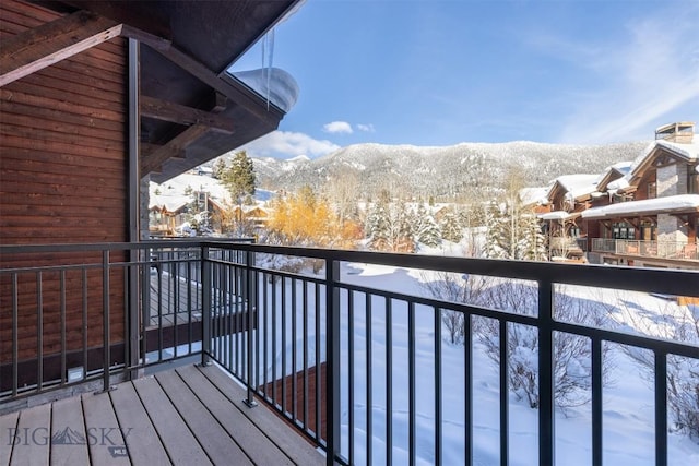 snow covered back of property featuring a mountain view