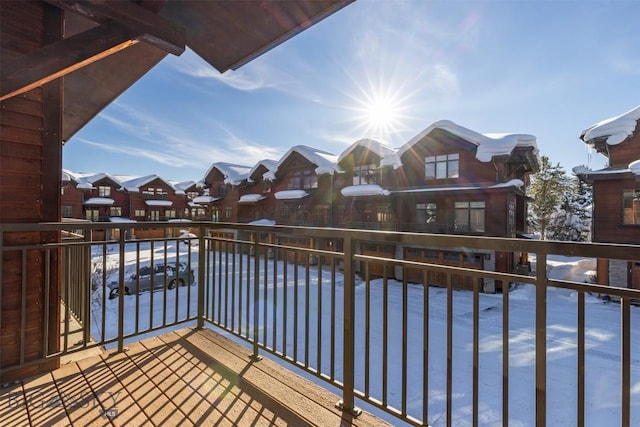 snow covered back of property featuring a residential view