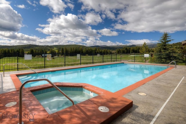 view of pool with a mountain view, an in ground hot tub, fence, and a fenced in pool