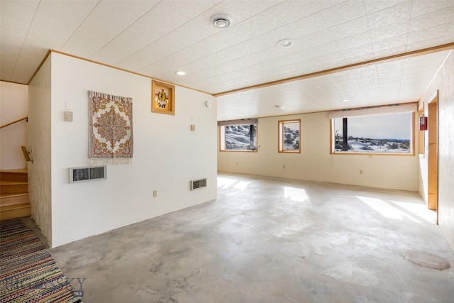 spare room with concrete flooring, stairway, and visible vents