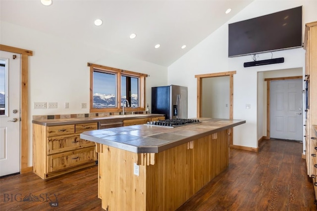 kitchen with dark wood-style floors, appliances with stainless steel finishes, stainless steel countertops, and a center island