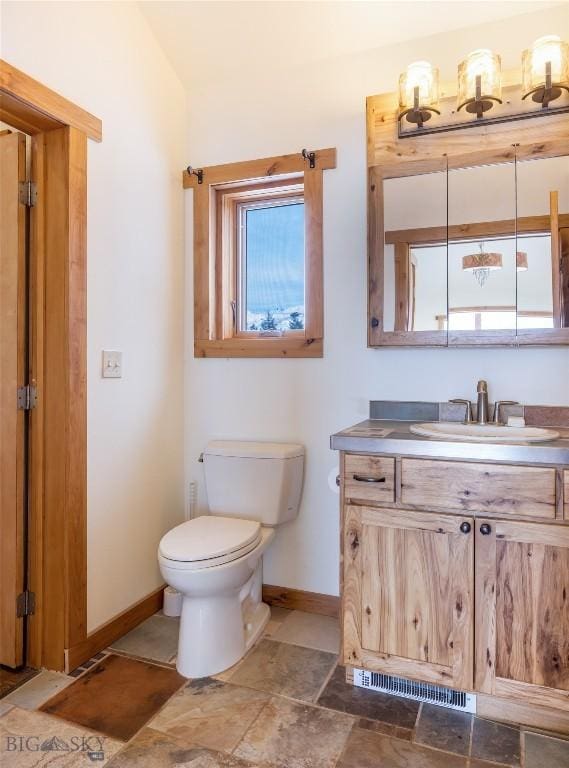 bathroom with toilet, baseboards, and vanity