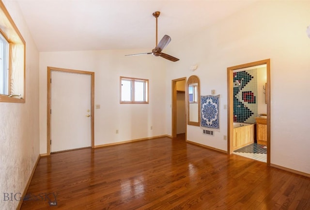 unfurnished living room with lofted ceiling, baseboards, a ceiling fan, and wood finished floors