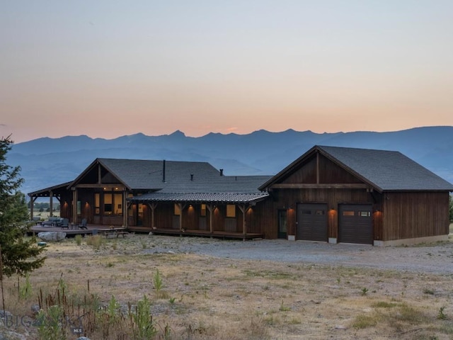 view of front of house featuring driveway, a mountain view, and metal roof