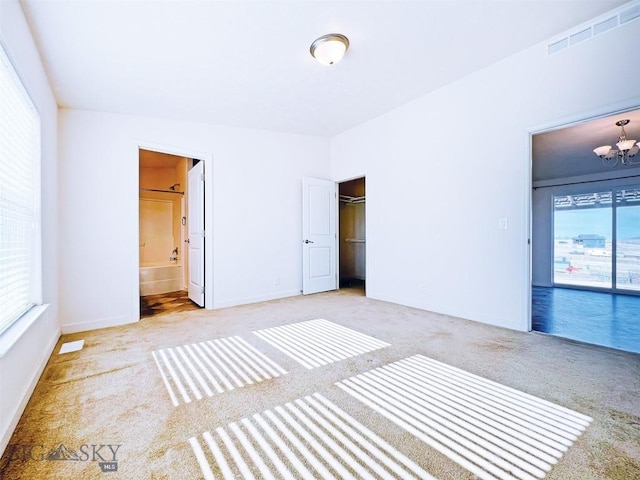 160 Expedition Dr, Dillon, MT 59725 - unfurnished bedroom with ensuite bath, carpet, visible vents, and a notable chandelier