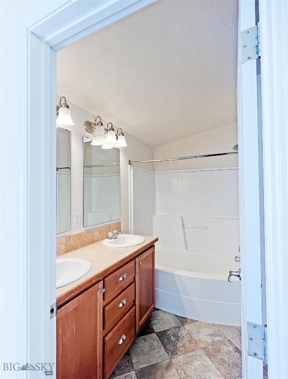 160 Expedition Dr, Dillon, MT 59725 - bathroom featuring a sink, a textured ceiling, and double vanity