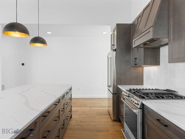 2820 S 30th Ave, Bozeman, MT 59718 - kitchen featuring stainless steel appliances, premium range hood, light wood-type flooring, tasteful backsplash, and pendant lighting