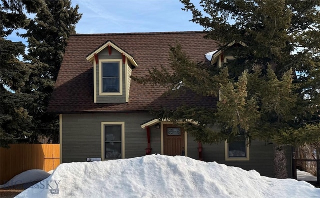 view of front of property featuring a shingled roof and fence