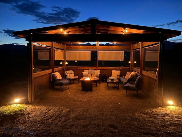 patio at twilight with an outdoor living space with a fire pit