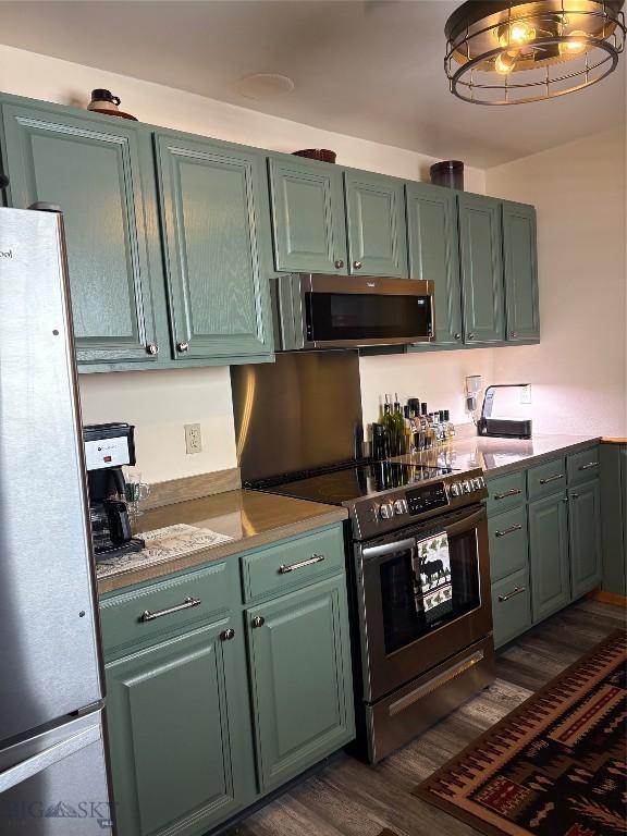 kitchen featuring dark wood-style floors, stainless steel appliances, and light countertops