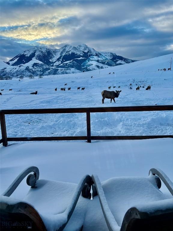 snow covered back of property with a mountain view