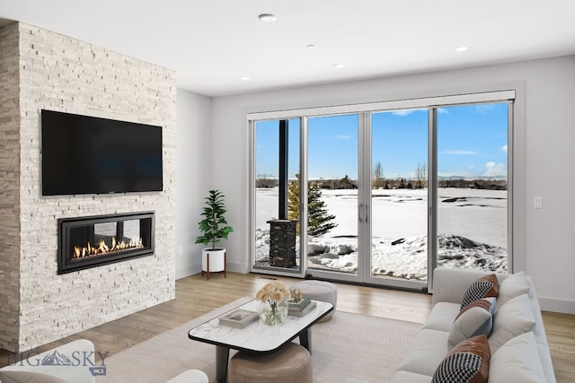 living room with recessed lighting, a fireplace, baseboards, and wood finished floors