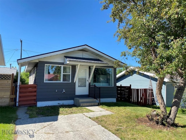 bungalow-style home featuring fence and a front lawn