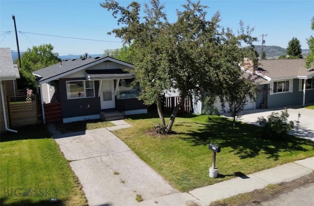 view of front of house featuring driveway, a garage, and a front yard