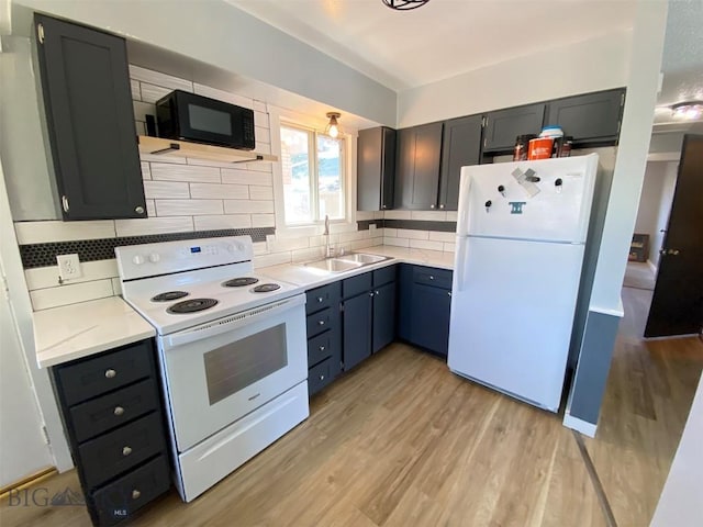 kitchen with white appliances, light wood finished floors, a sink, and light countertops