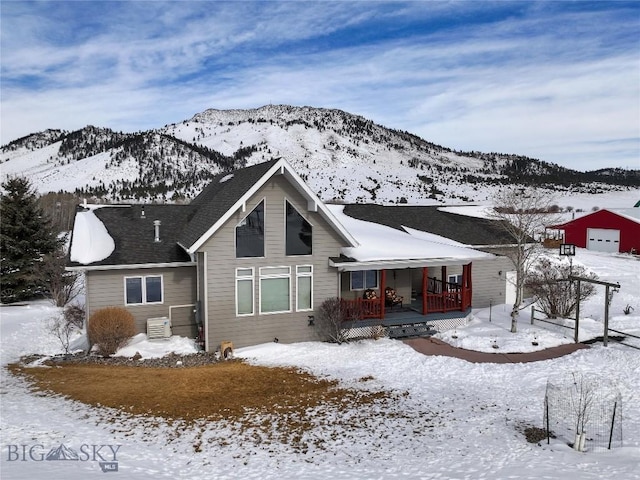 view of front of home with covered porch, a mountain view, and central AC