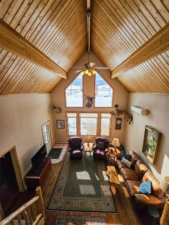 living room featuring wooden ceiling, ceiling fan, beamed ceiling, wood finished floors, and high vaulted ceiling