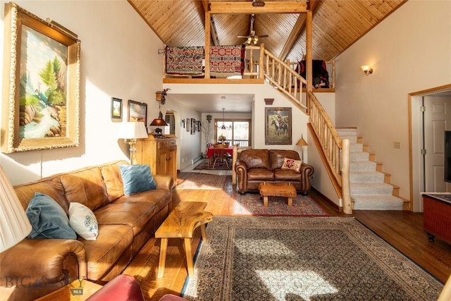 living room with ceiling fan, wood finished floors, high vaulted ceiling, wooden ceiling, and stairs