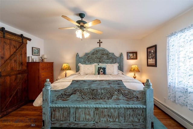 bedroom with a baseboard heating unit, a ceiling fan, wood finished floors, and a barn door